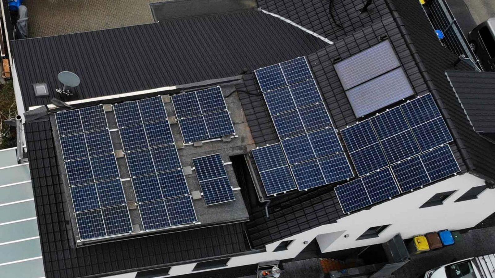 Luftaufnahme einer Photovoltaikanlage auf Sattel- und Flachdach eines Einfamilienhauses